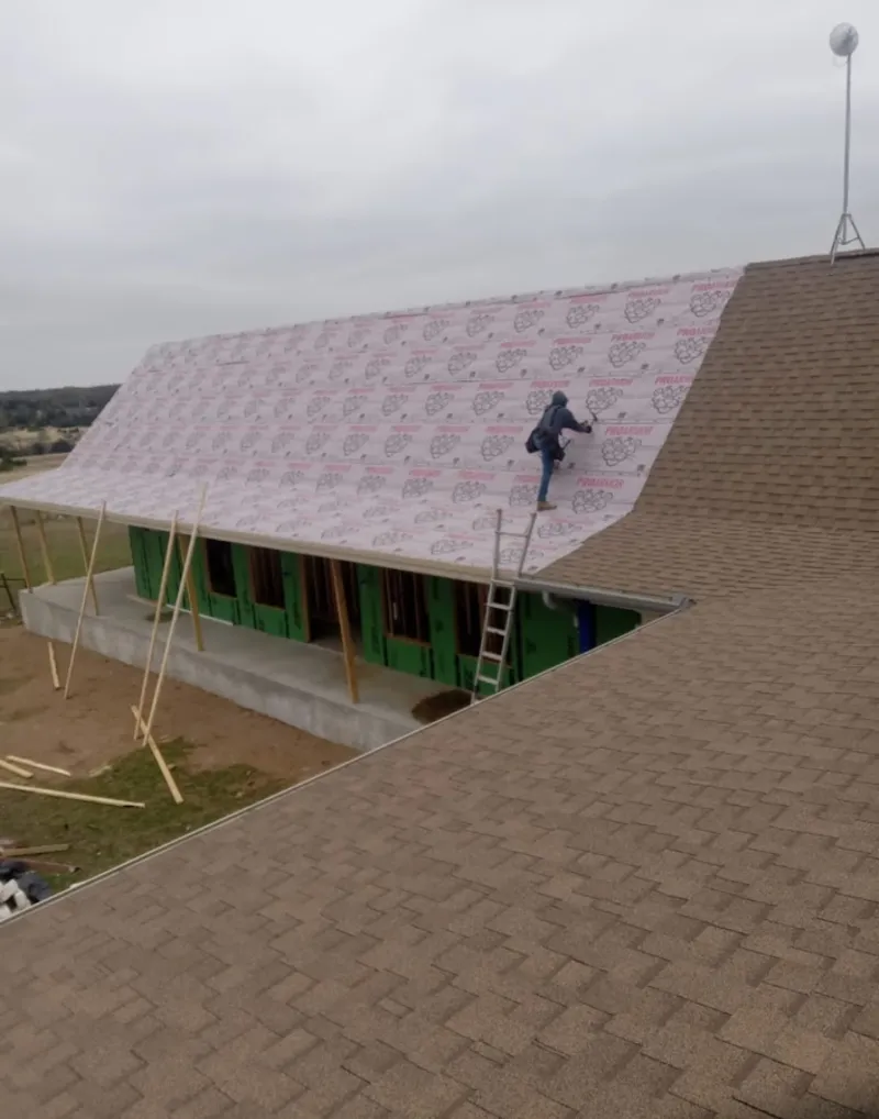 Worker preparing underlayment for a metal roof installation in Porterville